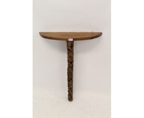 19th century carved yew wood bracket with bowed shelf on vine carved pierced supports, 64cm wide x 82cm high 