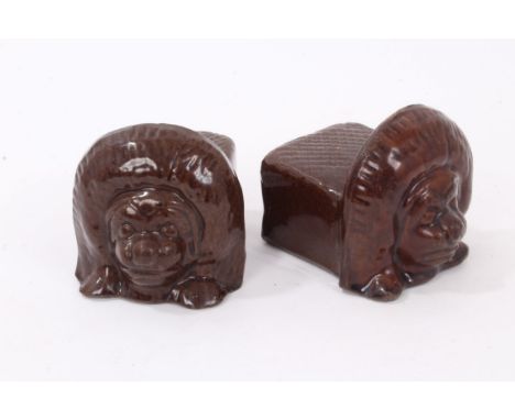 Pair of 19th century treacle glazed ceramic sash window rests, in the form of stylised lions, 8cm high 