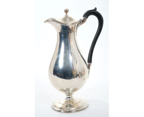 George III silver hot water jug of baluster form, with ebony loop handle, hinged domed cover with ball finial on a circular p