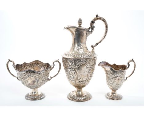 Late Victorian silver hot water jug of baluster form with embossed floral decoration and vacant cartouches, silver leaf mount