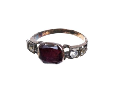 Mid-18th Georgian garnet and paste ring with a flat cut garnet in foil backed gold setting with paste stones to the openwork 