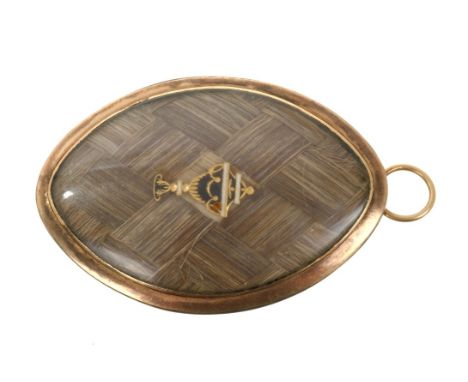 George III gold mourning pendant / brooch, the navette-shape plaque with applied gold and enamel urn on a plaited hair panel,