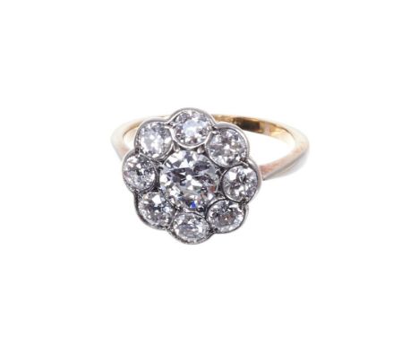 Diamond cluster ring with a flower-head cluster of old cut diamonds in platinum setting on yellow gold shank. Estimated total