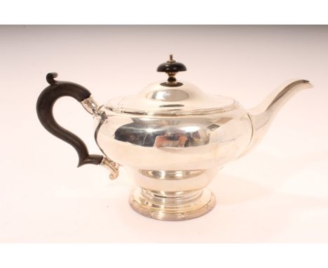 George V silver teapot of inverted baluster form, with reed and ribbon borders, ebony scroll handle and hinged domed cover wi