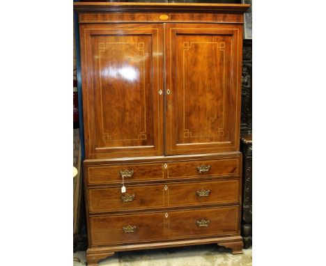 George III mahogany and boxwood line inlaid linen press, fitted with slides above enclosed by pair of panelled doors, the bas
