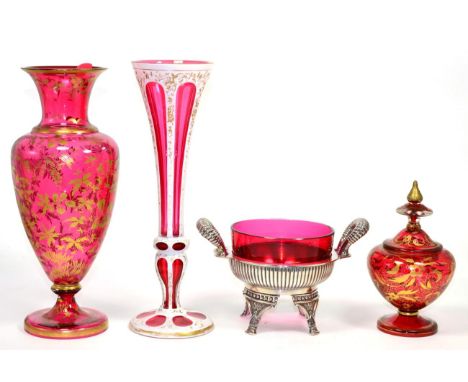 ~ A Victorian overlay ruby glass trumpet vase, two gilt pieces of ruby glass and a cranberry glass dish on plated stand