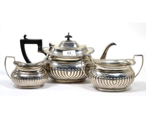 A matched silver three piece tea service, Shefield 1906/07, part fluted with gadroon and shell rim, the teapot 29cm long, 34o