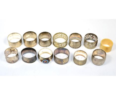 Six various silver napkin rings; and a group of plated examples, three applied with enamel badges; and a bone example, 5.2ozt