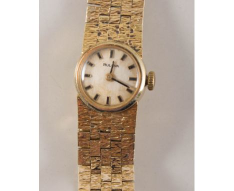 Lady's Bulova wrist watch, circular cream baton dial in a 20 micron gold-plated casew ith integral bark textured brick design