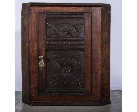 Joined oak hanging corner cupboard, in part 18th century, carved panelled door.  