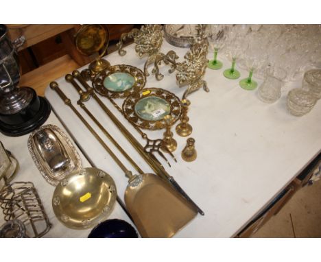 A set of three brass fire irons; together with a brass toasting fork; a pair of fire dogs etc. 