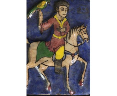 A Persian Qajar pottery tile, depicting a figure on horseback. H.19 W.14cm. 