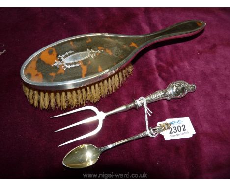 A silver and tortoiseshell Pique Clothes Brush, Birmingham 1924, continental silver handled bread fork stamped 925 (k) and a 