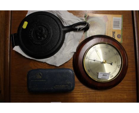 A waffle iron together with a barometer and a Rolls Razor