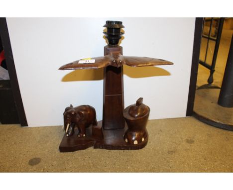 An Oriental carved hardwood table lamp with bird and elephant decoration