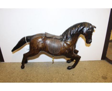 A vintage leather covered model of a galloping horse