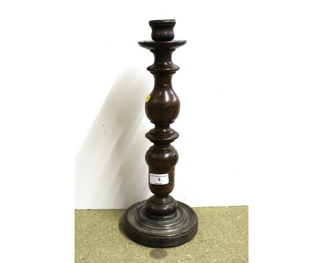 A 17th Century tall walnut candlestick together with a turned wooden pedestal bowl