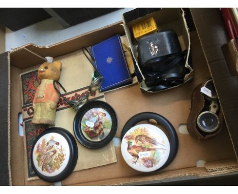 A box with various items including a Yoshika camera, Le Jockey Club - Paris binoculars, plaques, etc