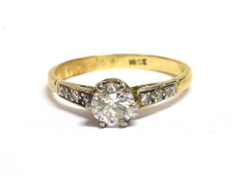 AN 18CT GOLD DIAMOND 0.5CT RING The ring set with a round cut diamond measuring 0.5mm in diameter with three tiny diamonds to