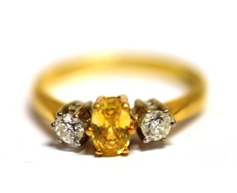 A CITRINE AND DIAMOND DRESS RING  The ring set with a single faceted oval citrine (0.6 x 0.4cm) flanked each side with a smal