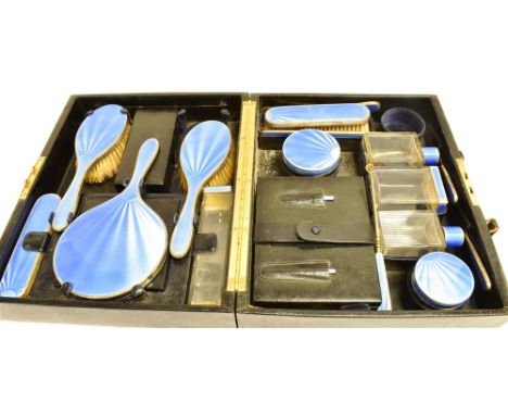 AN ART DECO SILVER AND ENAMEL SIXTEEN PIECE CASED VANITY/DRESSING TABLE SET  the set in blue sun ray pattern guilloche enamel