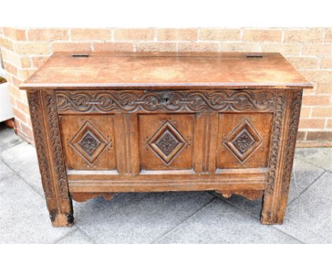 AN OAK COFFER  the triple panel front with carved decoration, later top, 11cm wide 49cm deep 69cm high