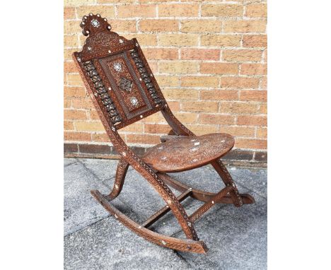 A MOORISH CARVED HARDWOOD FOLDING ARMCHAIR with mother-of-pearl inlay, the back with mashrabiya panels Condition Report : goo