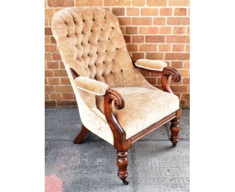 A VICTORIAN MAHOGANY FRAMED BUTTON UPHOLSTERED ARMCHAIR  on turned supports