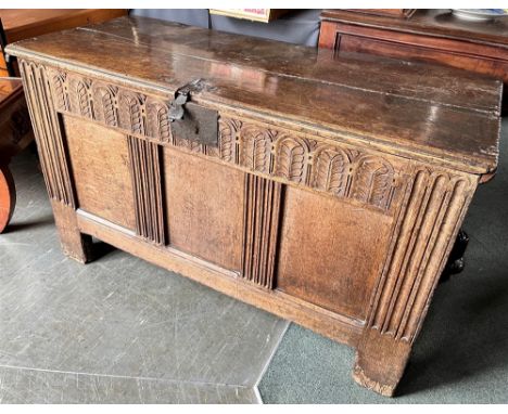 A CARVED OAK COFFER  with triple panel front, 116cm wide 51cm deep 69cm high