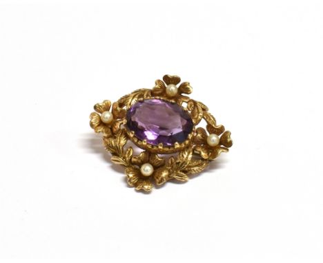 A 9CT GOLD, AMETHYST AND SEED PEARL BROOCH  the faceted oval amethyst measuring 1.7 x 1.4cm and centrally set in an open work