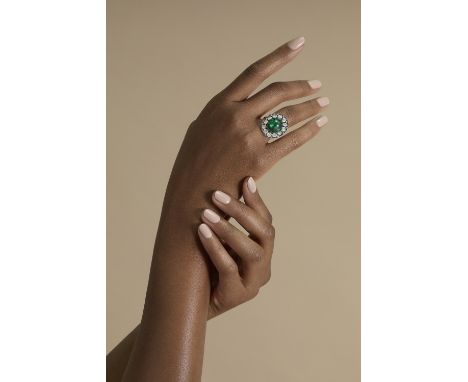 EMERALD AND DIAMOND RING, EARLY 20TH CENTURY, COMPOSITEThe cabochon emerald within a rose-cut diamond border, the diamonds in