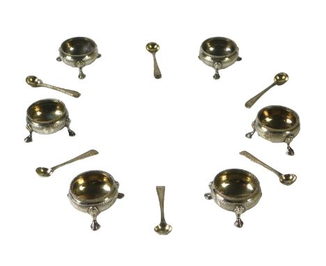 A set of six Victorian silver salts, each with an engine-turned band and three scroll feet, with matching spoons, in original
