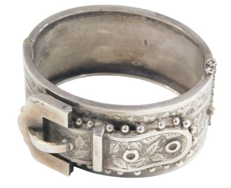An early 20thC silver belt and buckle bangle, with foliate engraving, on a snap clasp, with safety chain as fitted, boxed, 48