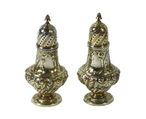 A pair of Victorian silver pepper pots, each cast with scrolls, etc, London 1882, 5oz, 11cm high.
