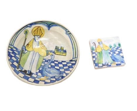 A studio pottery shallow dish, decorated with a Bishop beside a miniature church and a goose or swan, unmarked, 33cm diameter