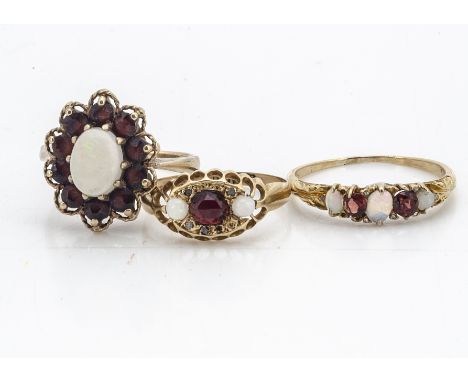 Two 18ct gold garnet dress rings, one set with white opals and rough cut diamonds centred with a faceted, domed garnet, ring 