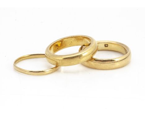 A 22ct gold court shaped wedding band, ring size I, another example ring size K 1/2, and a thin band ring size I, 14.4g (3)