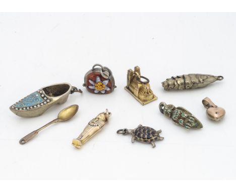 A miscellaneous collection of gold and silver charms, including a seed pearl and blue enamel heart charm, a 9ct gold and enam