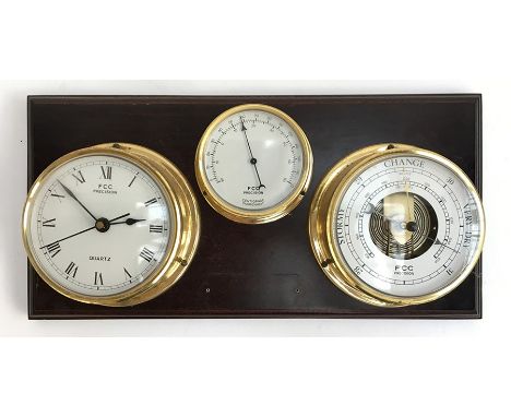 A clock, thermometer, and barometer set mounted on a wooden plaque