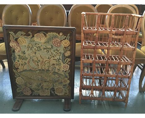 A French cane wine rack for 24 bottles together with an embroidered fire screen in wooden frame