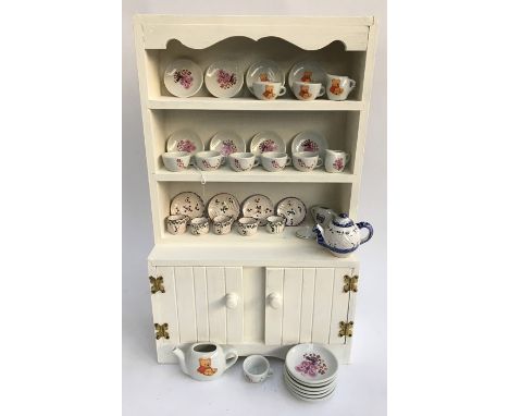 A painted pine miniature kitchen dresser with ceramics, together with a doll's tea service