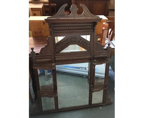 An early 20th century over mantle mirror with decorative carving and swan neck pediment