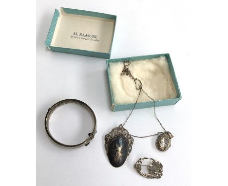 A 1975 Birmingham silver bangle bracelet with a hinge opening, safety chain and floral engraving. Weight approx 16g. Measures