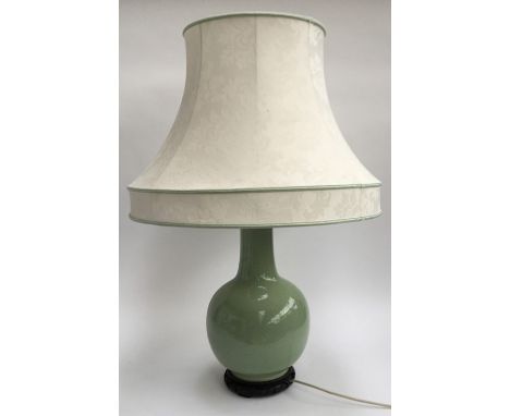 A large oriental ceramic Celadon table lamp on dark wood base with shade