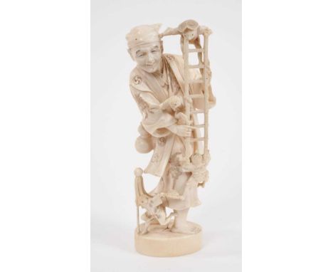 Late 19th century Japanese carved ivory figure of a street entertainer holding a ladder being climbed by bird like creatures,