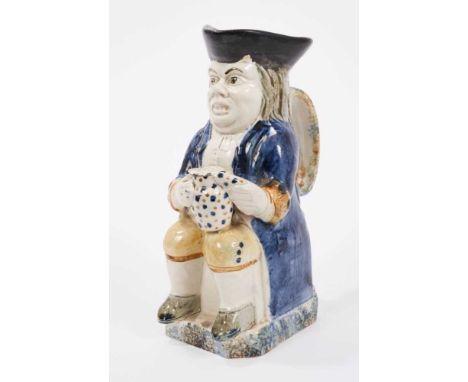 Prattware Toby jug, circa 1800, shown seated and holding a jug of frothing beer, wearing a blue jacket and yellow breeches, w