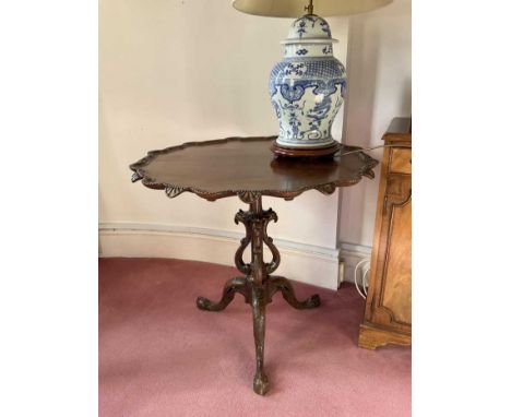 Chippendale style carved mahogany piecrust side table, with carved dished top and tripod base with eagles head decoration. 80