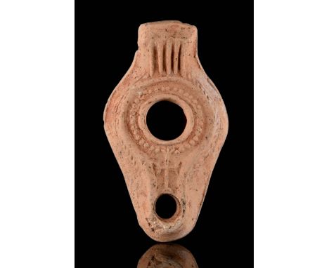 Circa 100-200 AD A pottery oil lamp with convex body, incised floral decoration around the fill hole and nozzle, with a large