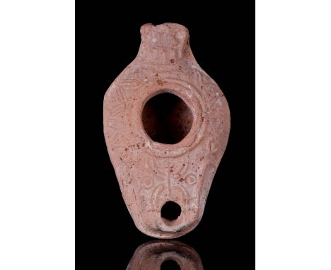 Circa 100-200 AD A pottery oil lamp with convex body, incised decoration around the fill hole and nozzle. The lamp features a