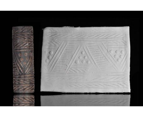 Circa. 3000 B.C. A black stone cylinder seal, decorated with pattern of triangles with hatched bands and dots.The seal is acc